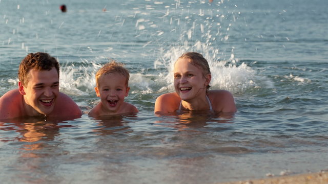Young family splashing in the sea