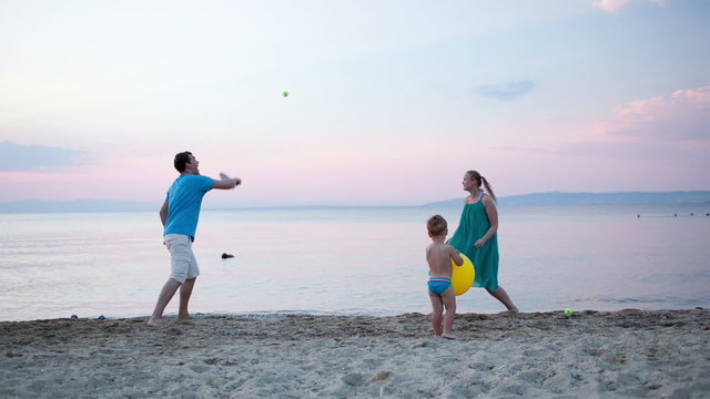 Young family playing tennis at the seaside