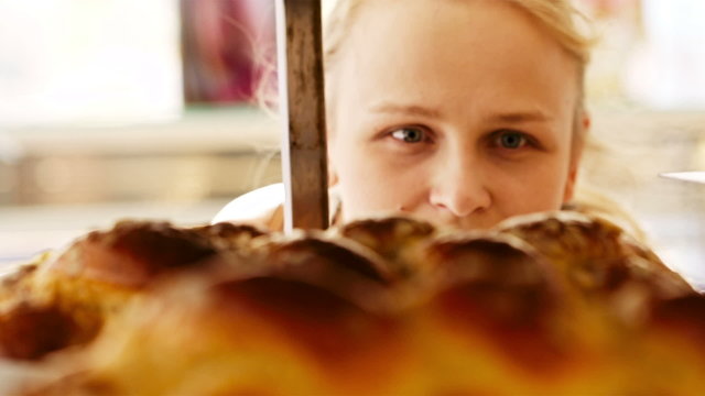 Young woman looking through bakery window
