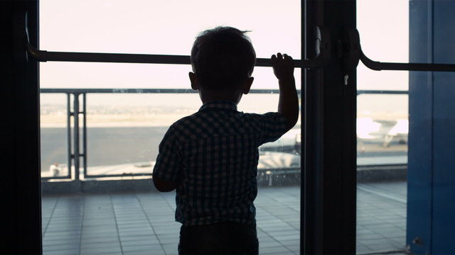 Young boy looking through window in the airport