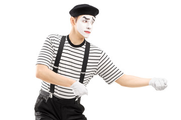 Male mime artist performing pulling virtual rope