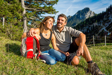 Fototapeta premium Paar macht Pause auf einer Wiese in den Bergen