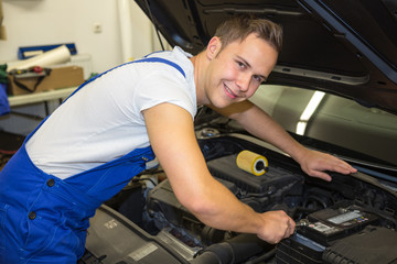 Mechanic with tools in garage repairing the motor of a car