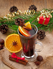 Obraz na płótnie Canvas Christmas mulled wine in glass cup on a wooden table
