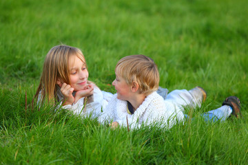 Two kids enjoy life in the grass.