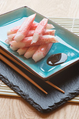 Fresh raw sushi crabsticks on plate with chopsticks