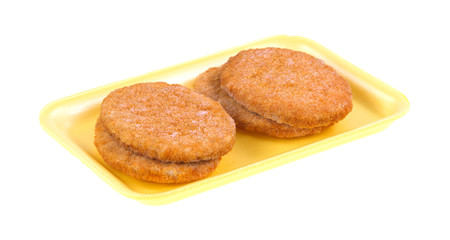 Veal patties on a yellow foam tray
