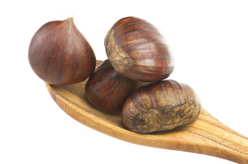 Wooden spoon  with chestnuts close up on the white