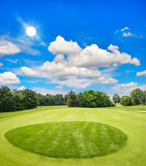 green golf course and blue sunny sky