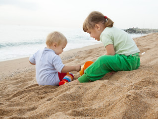 hildren playing with sand at sea