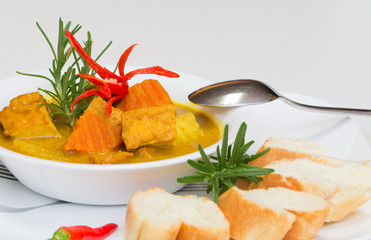 Hot, delicious tofu curry served with breads on white background
