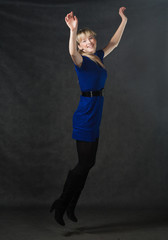 Fototapeta na wymiar Success - young active businesswomen jumping in blue dress.