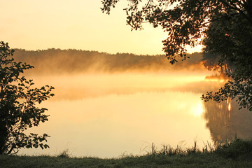 Fototapeta na wymiar foggy lake at sunrise