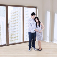 Happy pregnant couple at apartment