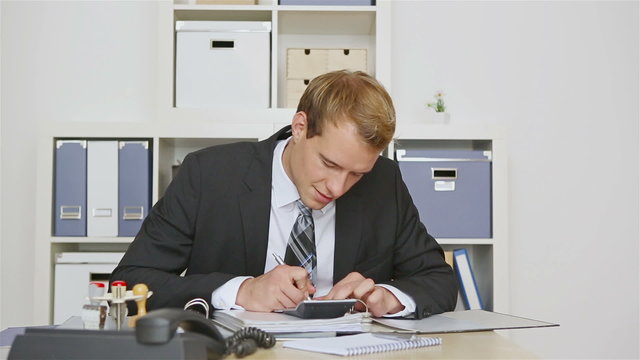 Businessman in office holding thumbs up sign