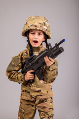 Young boy dressed like a soldier with rifle