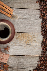Coffee cup with spices and chocolate on wooden table texture