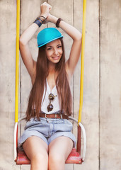 hipster girl sitting on a swing