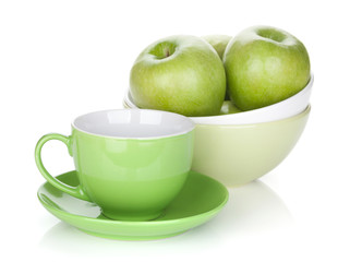 Green apples in fruit bowl and tea cup