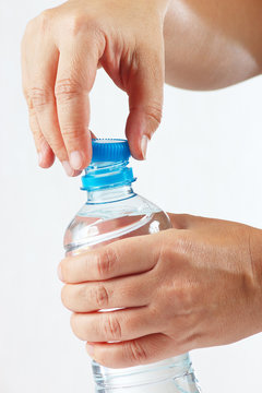 Hands opening a small bottle of fresh water