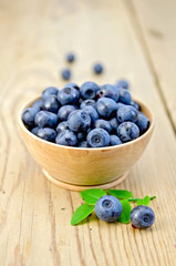 Blueberries in a wooden bowl on the board