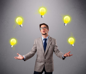 young man standing and juggling with light bulbs