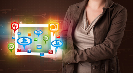 Girl presenting a tablet with colorful social icons and signs
