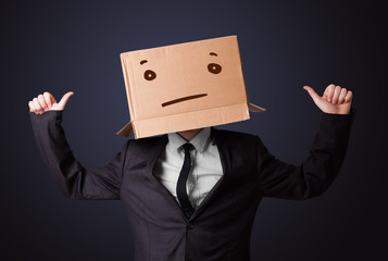 Businessman gesturing with a cardboard box on his head with stra