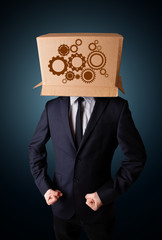 Businessman gesturing with a cardboard box on his head with spur