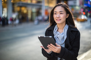 Asian woman in New York City using ipad tablet pc