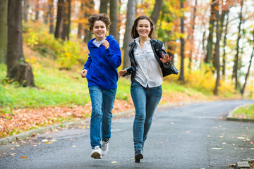 Fototapeta premium Dziewczyna i chłopak, bieganie, skakanie w parku