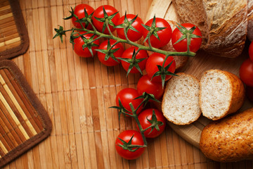 Tomatoes and breadon the wooden mat