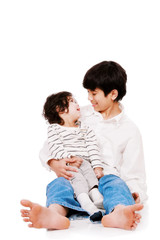 Big brother holding disabled two year old child. Child has cereb