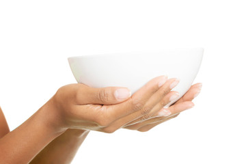Female hands holding a bowl. Closeup.