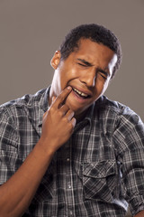 African man shows with his finger on the tooth that hurts him