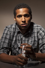 serious dark-skinned young man mixing poker cards