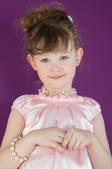 Beautiful girl in a pink dress with a beads and bracelet