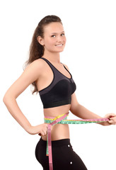 Fit girl measuring her waist with three measuring tapes.