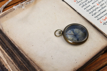 compass and watch on old book