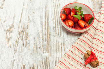 Fresh strawberries in bowl over wooden background