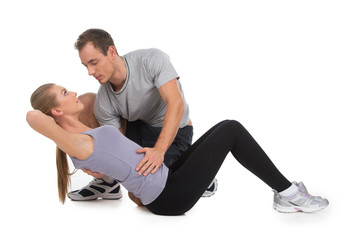 Nice woman exercising with her personal trainer.