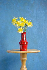 yellow fresh spring narcissus in red vase