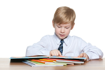 Young boy is reading at the desk