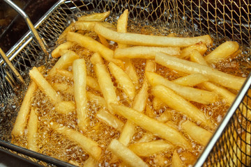 French fries in a deep fryer closeup - 57706636