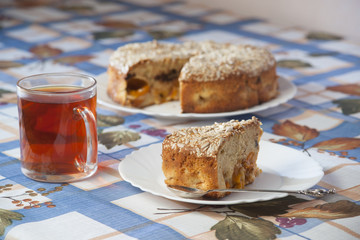 Apricot pie on plate and cup with tea