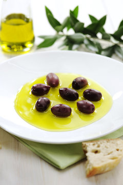 Olive Oil and Black Olives on a Plate with Bread