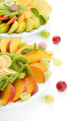 Assortment of sliced fruits on plates, isolated on white