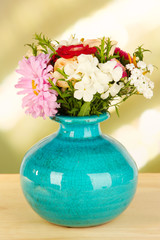 Beautiful bouquet of bright flowers in color vase,