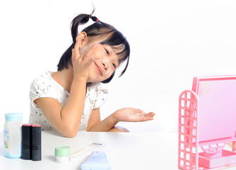smiling asian little girl is applying make up baby powder her fa