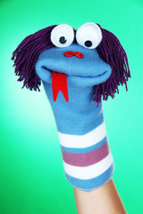Cute sock puppet on green background